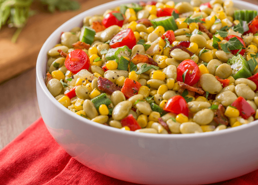 Succotash Salad with corn, diced tomatoes, beans in a large white bowl.