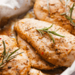 Three lightly seasoned chicken breasts.