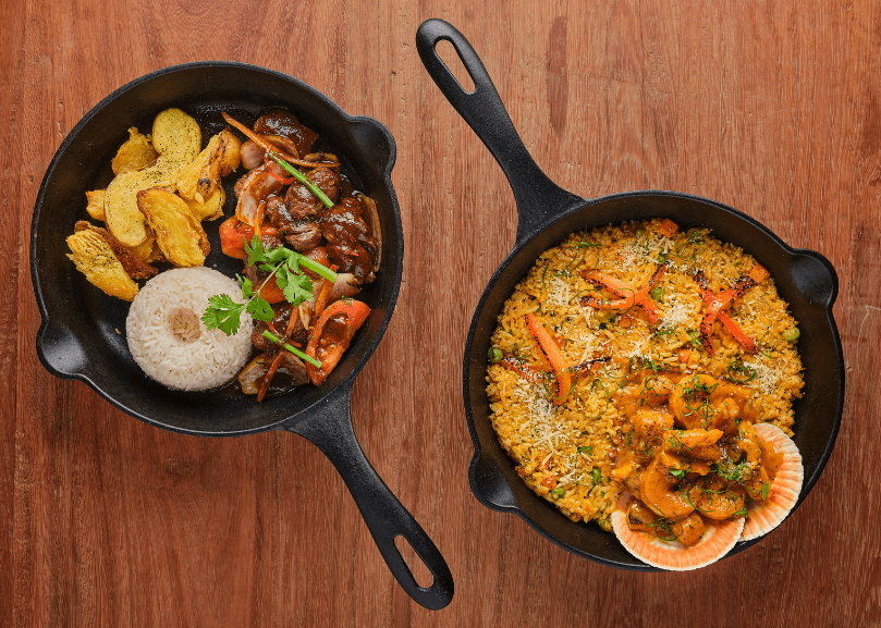 One skillet with white rice, potatoes, and beef and another skillet with rice and vegetables.