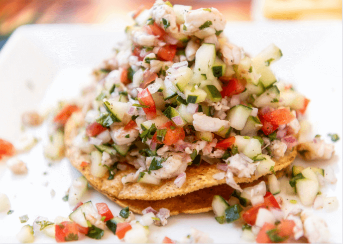 Chopped tomato, onion, pepper, scallions on top of hard shell tortillas.