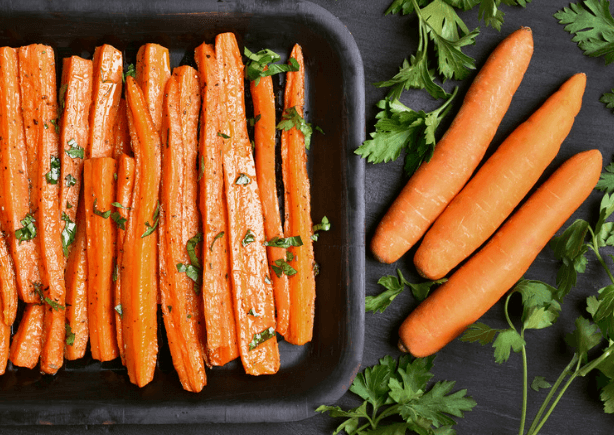 Chopped carrots in a dish with whole carrots on the side.