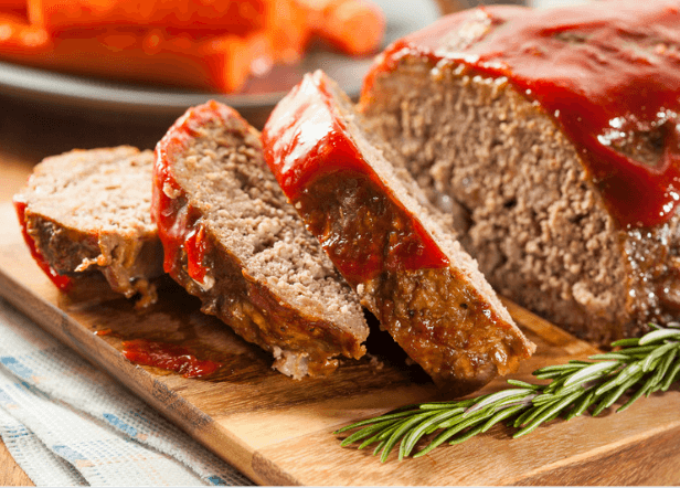 Slices of meatloaf on wooden cutting board.