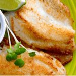 Tilapia with lime and dip on a green plate.
