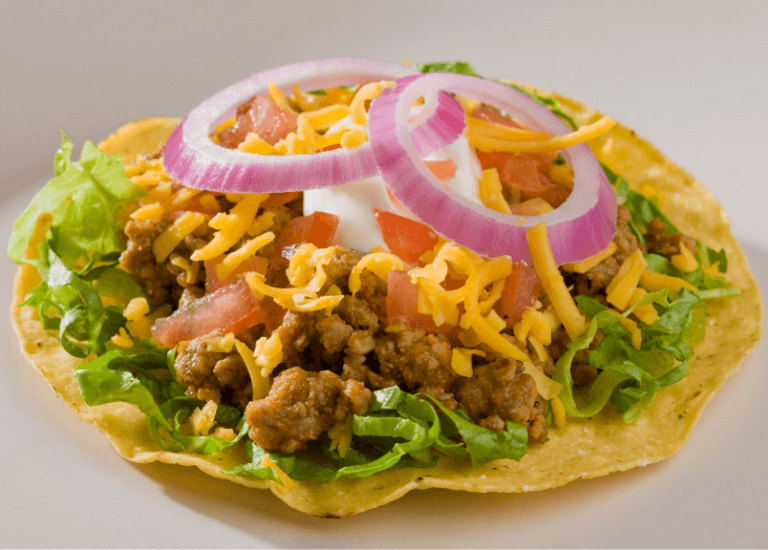 Turkey Tostadas with lettuce, tomato, red onion, cheese, and sour cream.