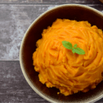 Whipped sweet potatoes in a small brown bowl.
