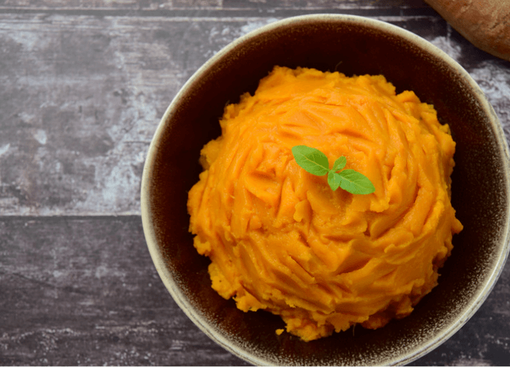 Whipped sweet potatoes in a small brown bowl.