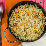 Cauliflower stir fry with chopped vegetables in a pot with a fork next to it.