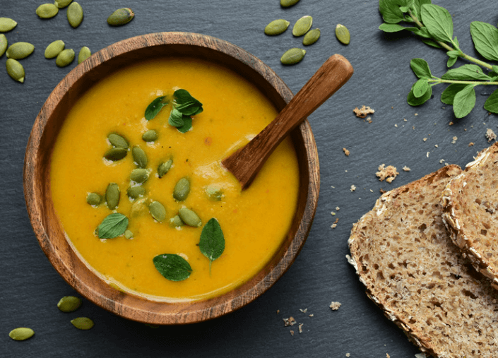 Curried coconut butternut squash soup in a wooden bowl.