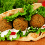 Pita wrap with three falafel, lettuce, and yogurt.