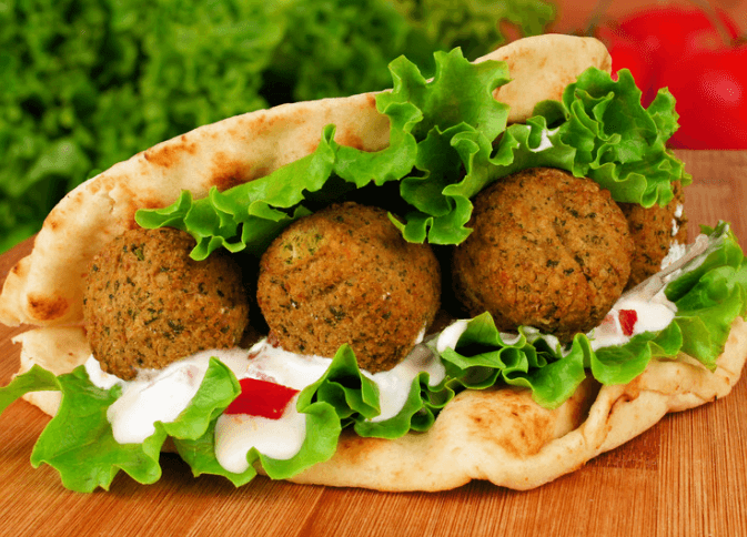 Pita wrap with three falafel, lettuce, and yogurt.