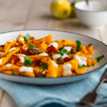 Harvest roasted salad with pecans, kabocha squash in a white bowl.