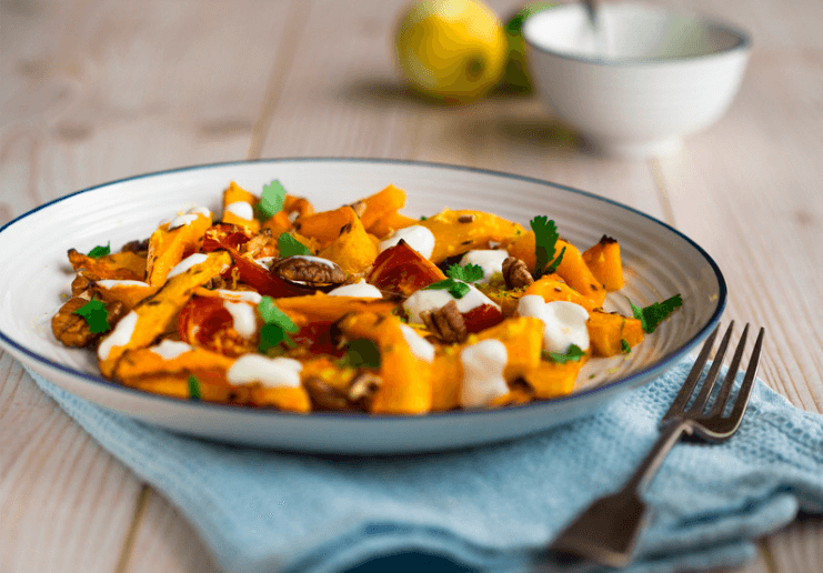 Harvest roasted salad with pecans, kabocha squash in a white bowl.