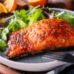 Honey glazed salmon with lettuce and orange slices.