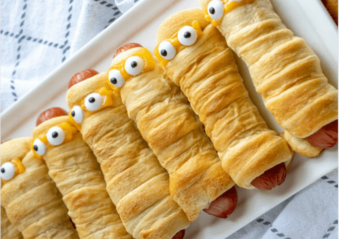 hot dogs wrapped in crescent rolls with eyes to resemble mummys.