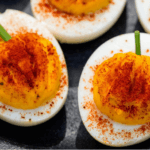 Deviled eggs with yolks that resemble pumpkins.