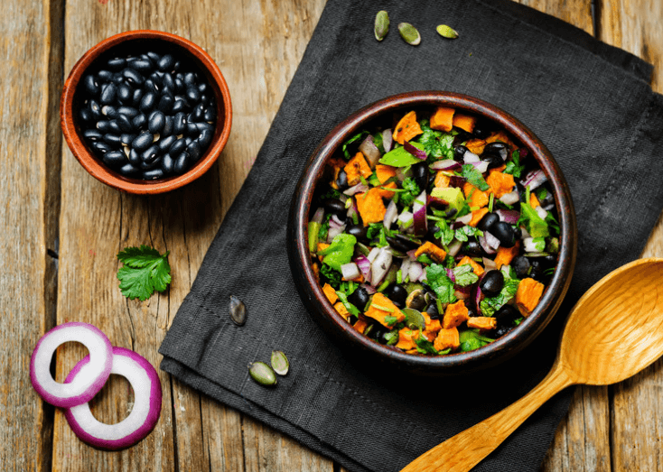 Roasted Sweet Potato Salad with bowl of black beans next to it.