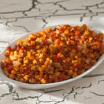 diced sweet potatoes, apples, and red peppers in a baking dish.