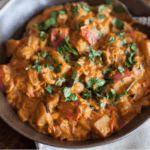 Eggplant and diced potatoes curry in a dark bowl.