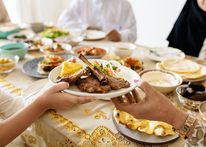 Two hands passing a plate at the dinner table.