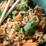 Ramen noodles with chop sticks, carrots, broccoli, and peanuts.