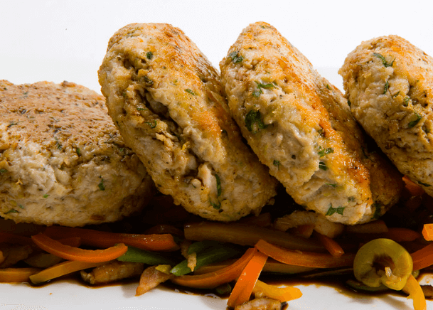 Tuna melt patties on top of sautéed vegetables.