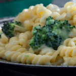 Pasta with broccoli on a dark plate.