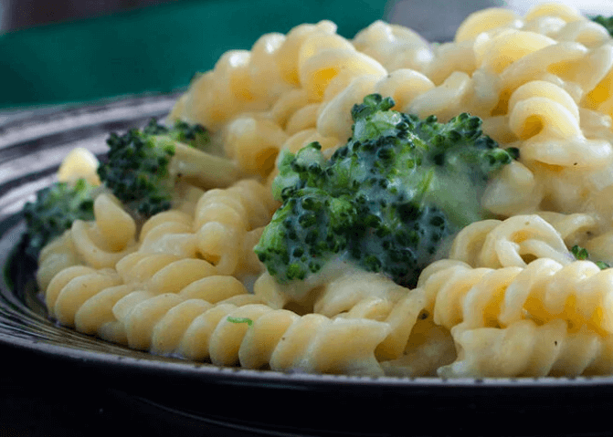 Pasta with broccoli on a dark plate.