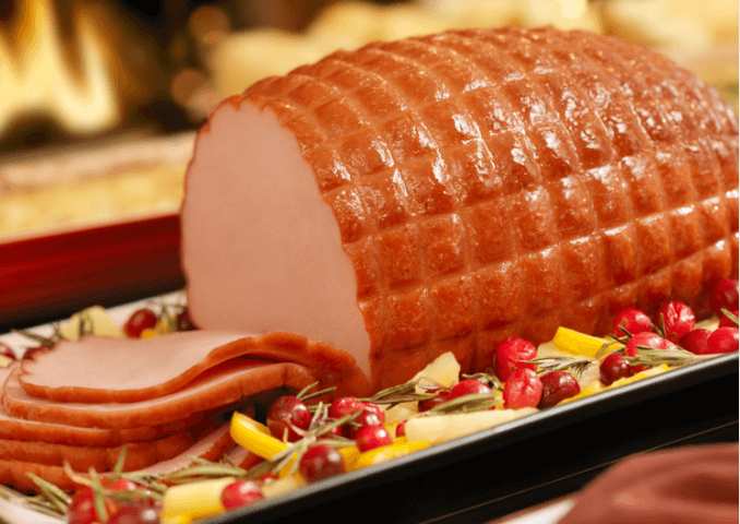 Sliced ham on platter with cranberries.