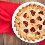 Apple cranberry pie on a red table cloth.