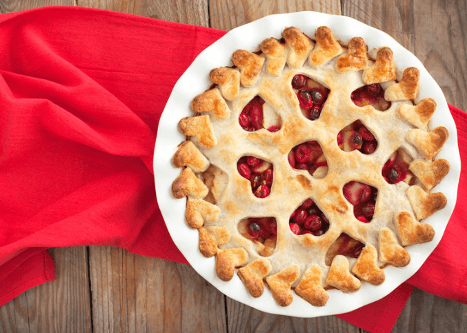 Apple cranberry pie on a red table cloth.