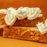 Two slices of carrot pie with whipped cream.