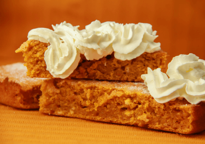 Two slices of carrot pie with whipped cream.