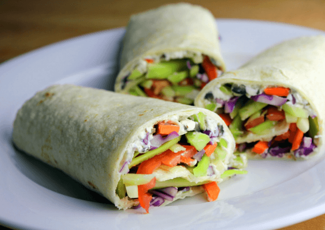 Three vegetable wraps on a white plate.