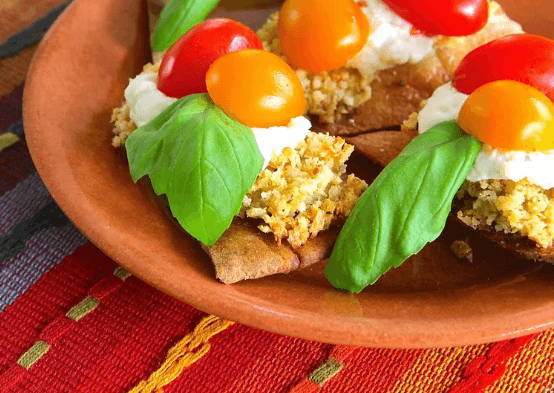 Eggplant in breadcrumbs with tomatoes and basil on top.