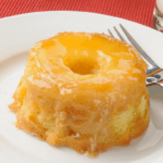 Upside down pineapple cupcake on a white plate.