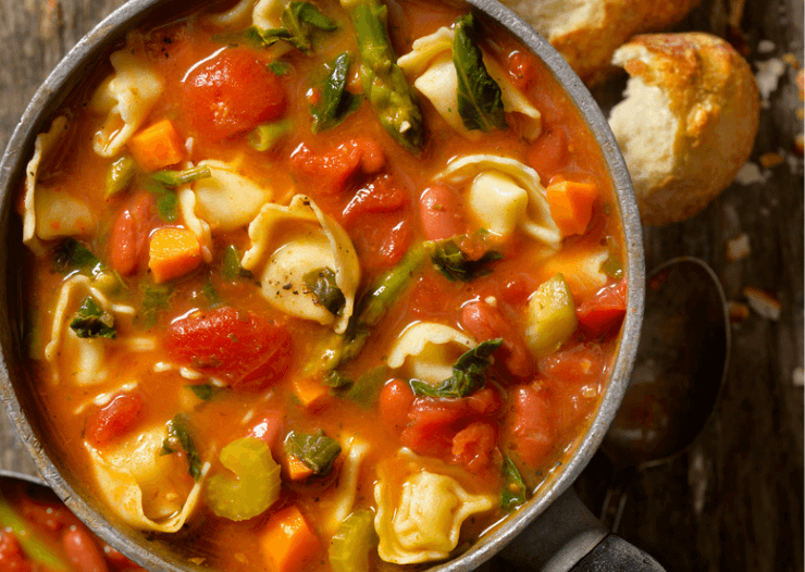 Tortellini and vegetable soup in a large bowl.