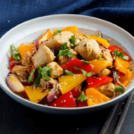 Chicken and stir fry vegetables in a white bowl.