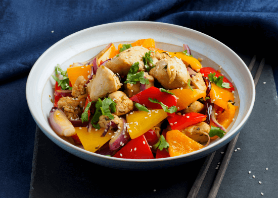 Chicken and stir fry vegetables in a white bowl.