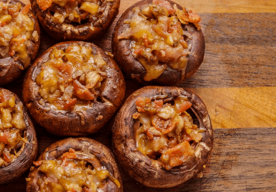 Stuffed mushrooms on a wood board.