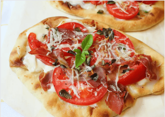 Naan bread margherita pizza with tomatoes and cheese.