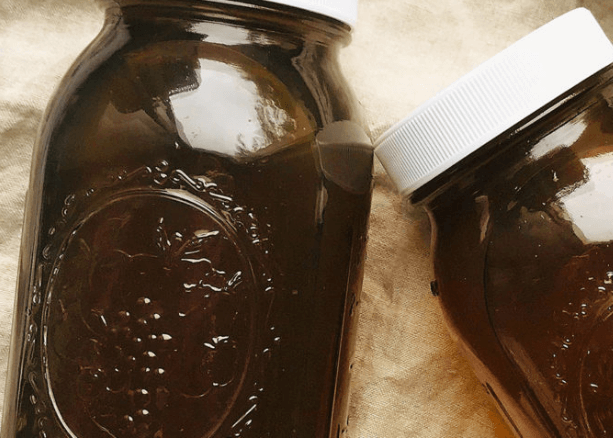 two mason jars with dark vegetable broth.