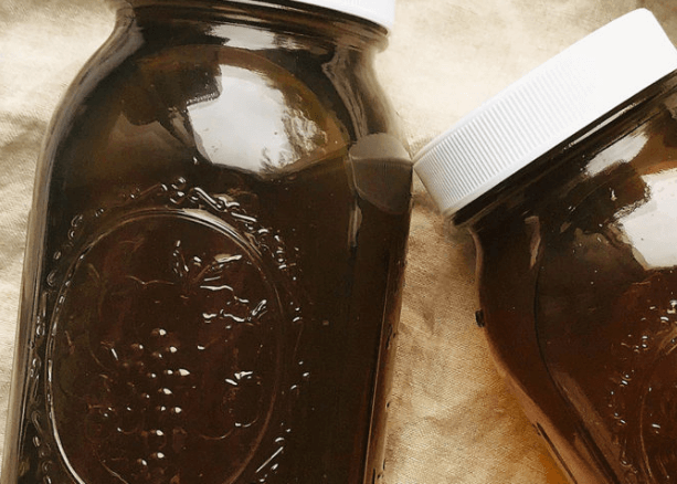 Two mason jars with dark vegetable broth.