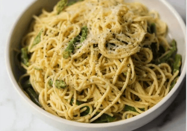 Spaghetti noodles with asparagus and white sauce.