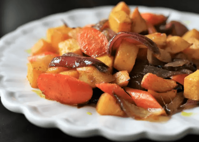 Diced onions, rutabaga, and carrots on a white plate.