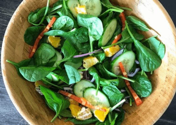 Spinach, cucumber, oranges, and red bell pepper salad.