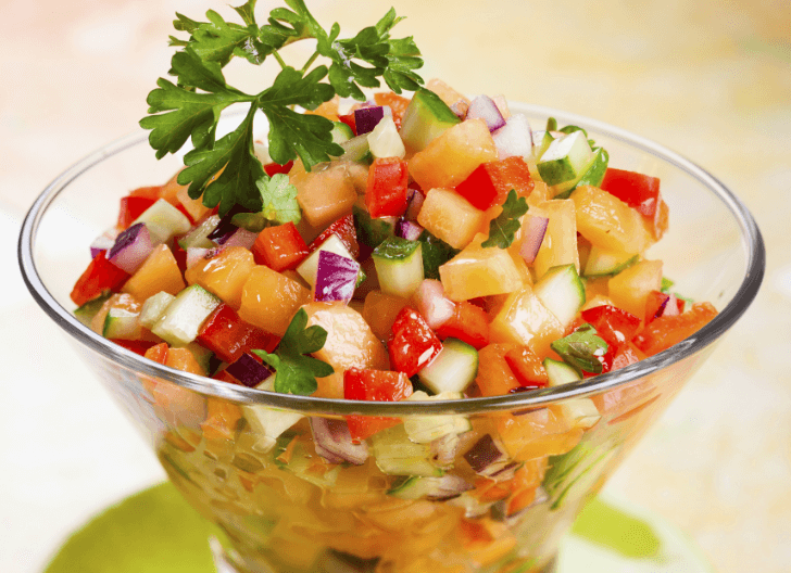 Diced peach, pineapple, and cucumber in a clear glass bowl.