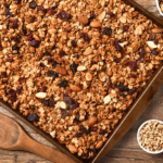Granola with oats and nuts on a baking sheet.