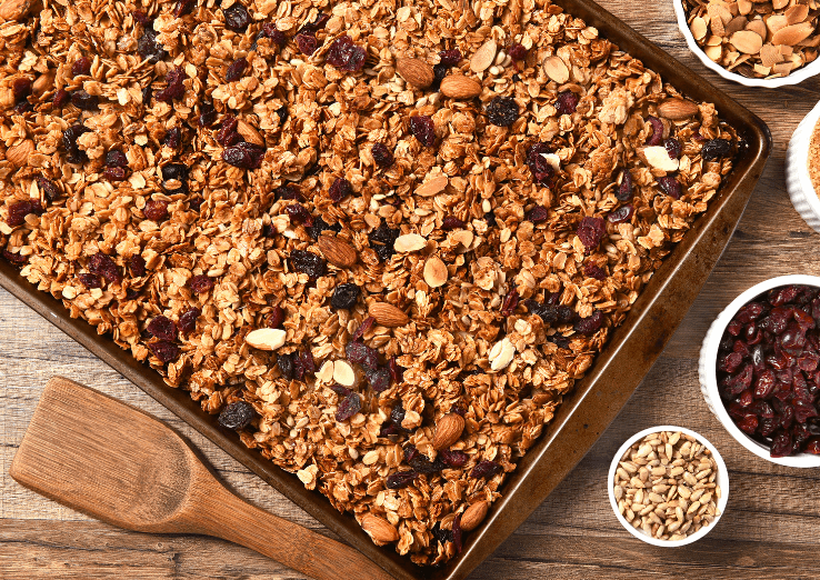 Granola with oats and nuts on a baking sheet.