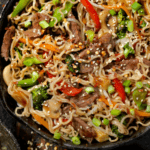 A cast iron pan of ramen noodle stir fry