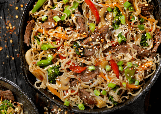 A cast iron pan of ramen noodle stir fry